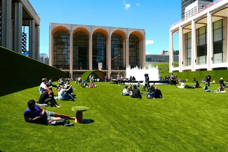 People enjoying a spring day on grass installation at Lincoln Center - Image by Joe Tabacca